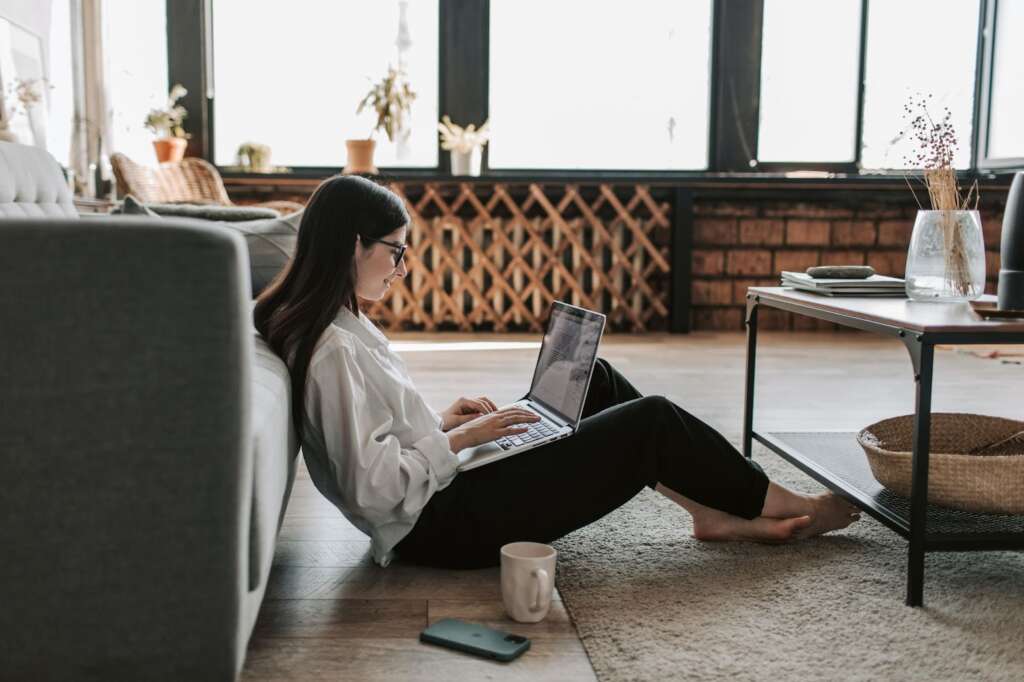 An employee looking relaxed in their home while working remotely.