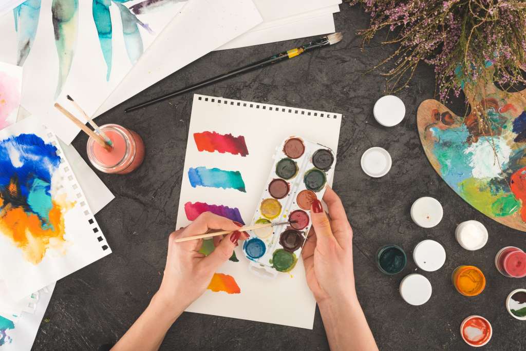 Cropped image of artist mixing watercolor paints